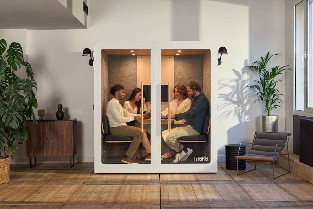 Four colleagues in a meeting inside a large acoustic meeting pod