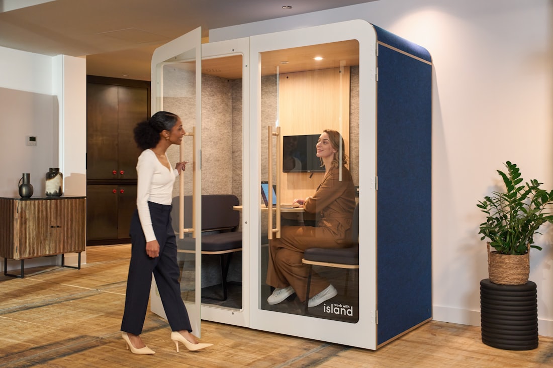 Colleague approaching an acoustic pod installed in an open-plan office